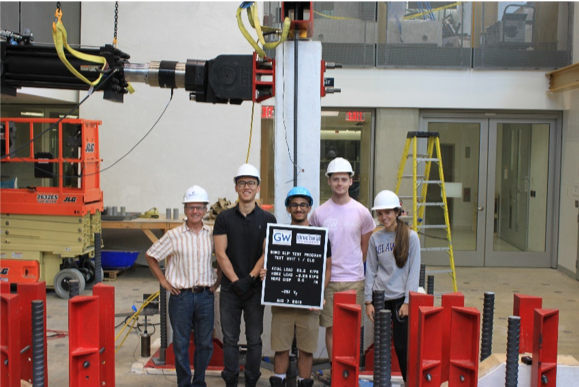 professor and 4 student standing in the high bay