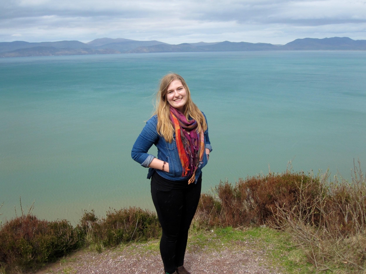 Student smiling and standing near water in Ireland