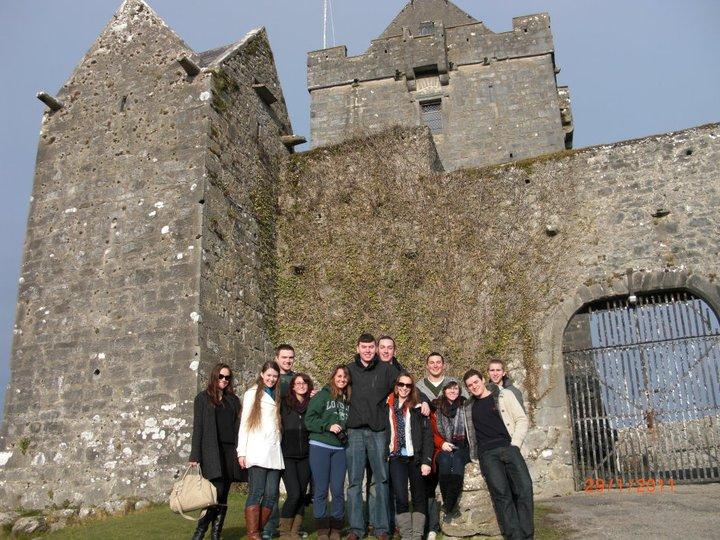 group of students standing in front of a castle