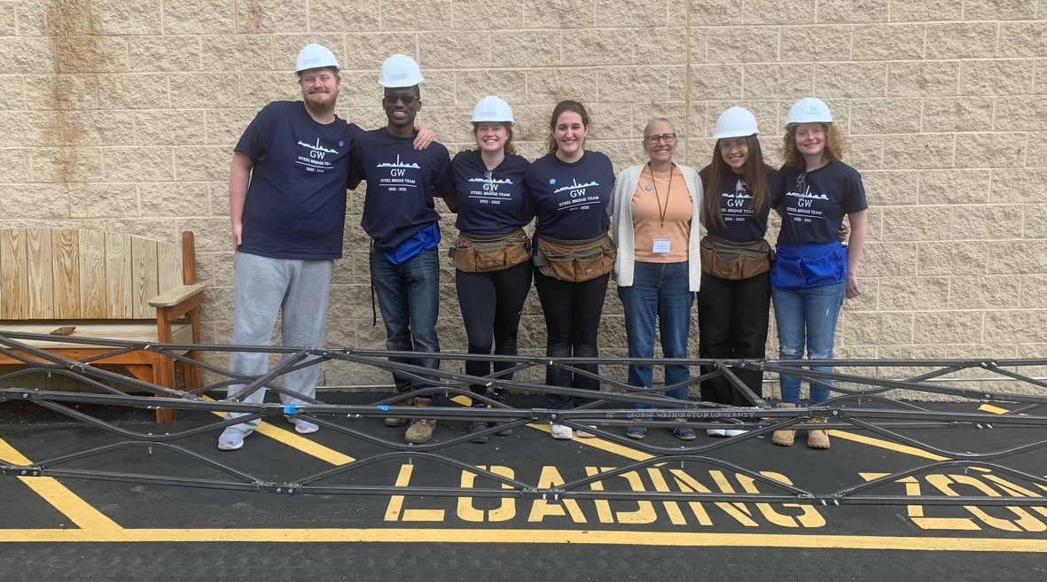 steel bridge team posing with Professor Roddis in front of bridge design