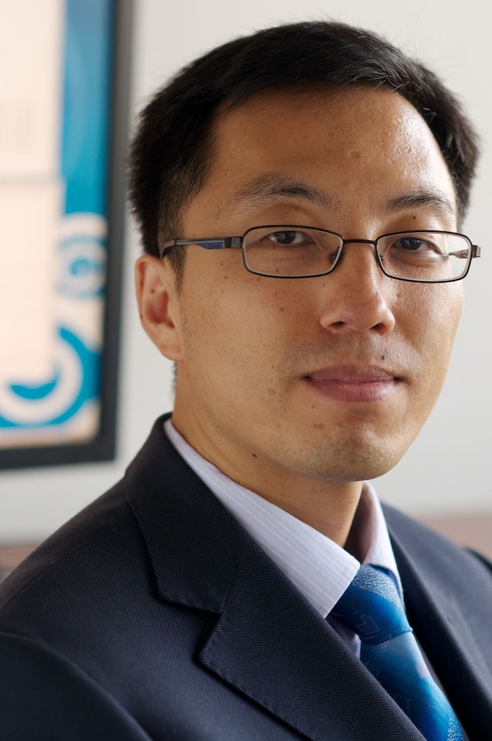 Man in a navy suit and teal tie