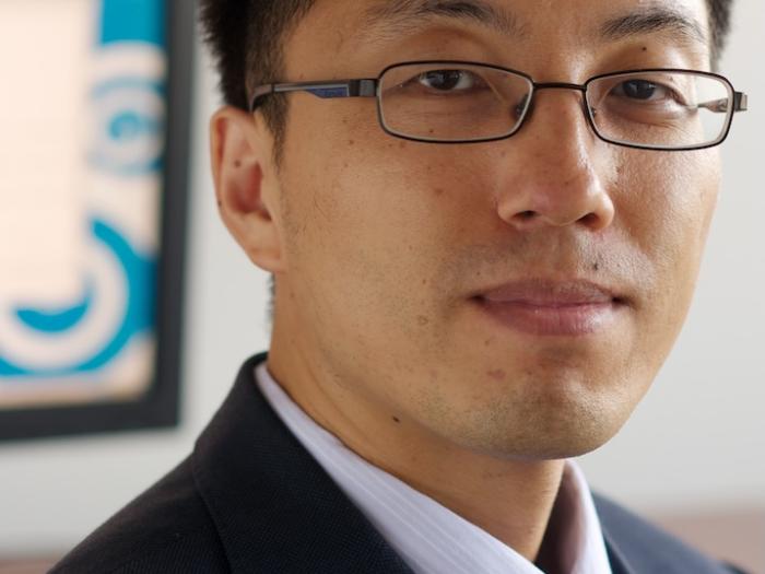 Man in a navy suit and teal tie