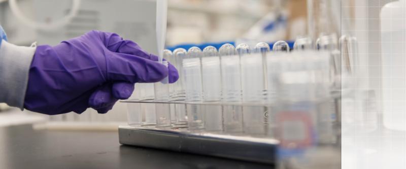 gloved hand grabbing a test tube