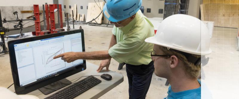 professor and student working at a computer in the highbay