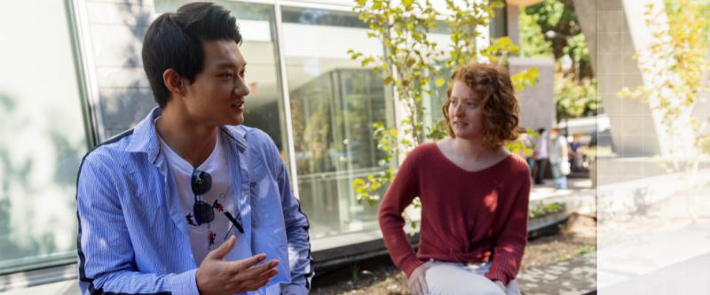 two students sitting outside of the science and engineering hall