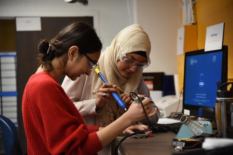 two students soldering
